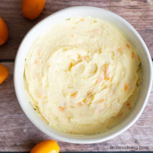 A closeup of the creamy kumquat honey butter in a white bowl.