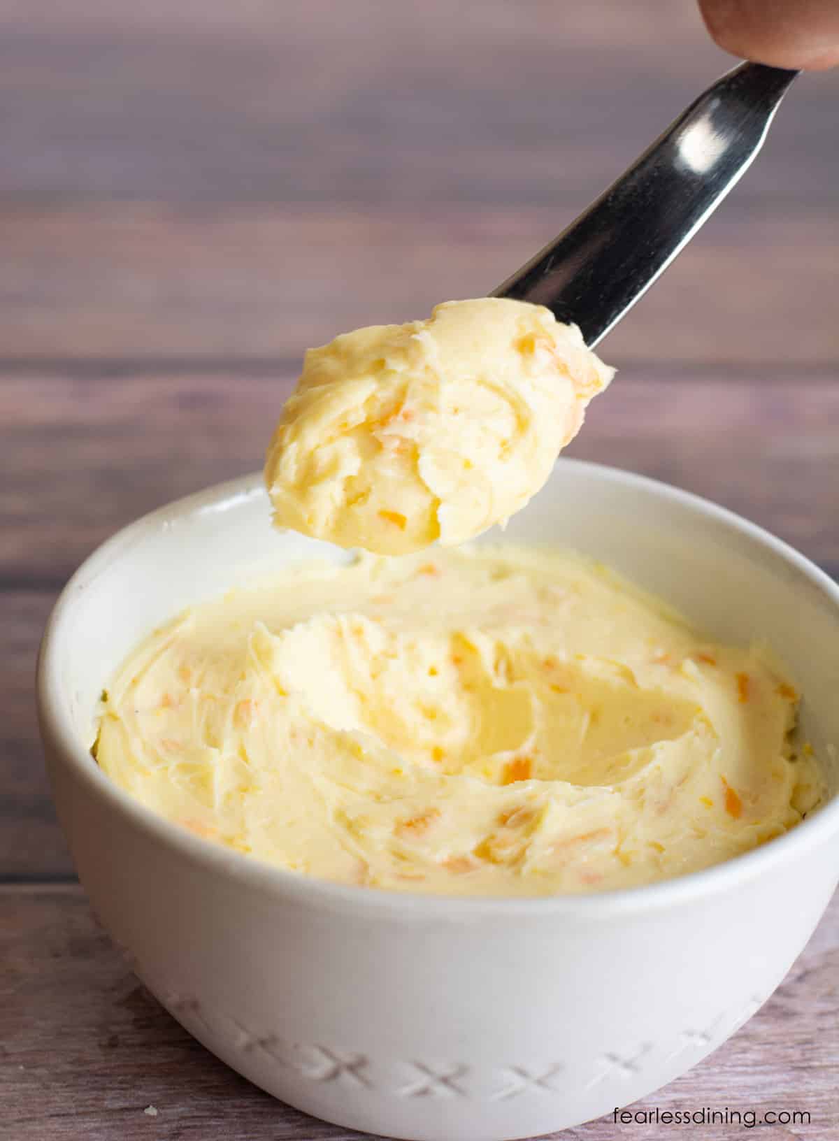 Some of the honey butter being held up on a butter knife.