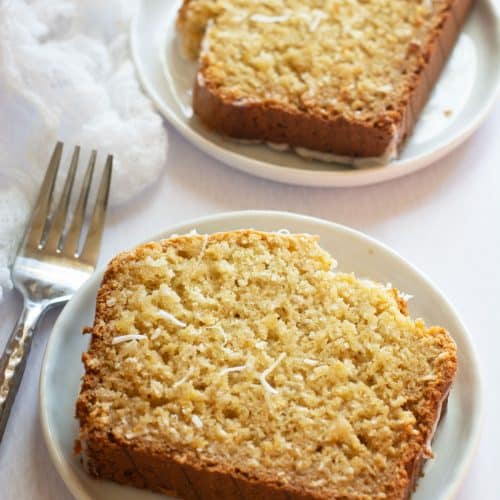 Two slices of the gluten-free coconut pineapple cake on small white plates.