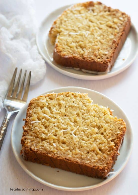 Two slices of the gluten-free coconut pineapple cake on small white plates.