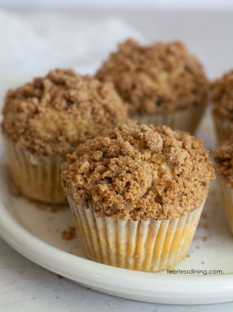 A white plate with gluten-free coffee cake muffins on it.