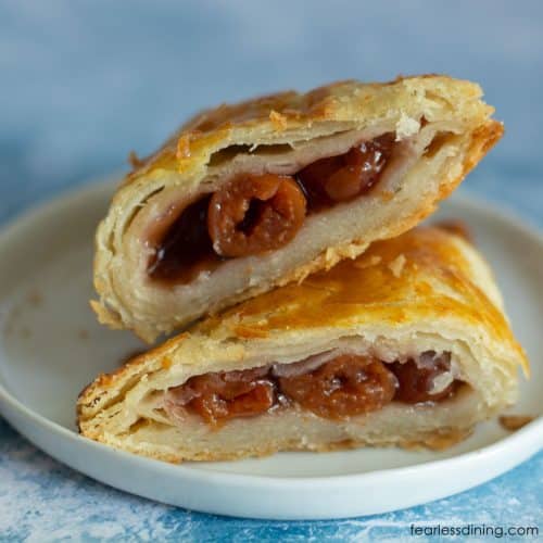 A gluten-free cherry turnover cut in half so you can see the flaky layers.