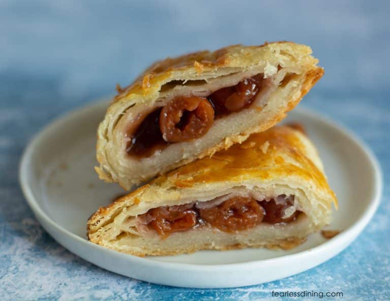 A gluten-free cherry turnover cut in half so you can see the flaky layers.