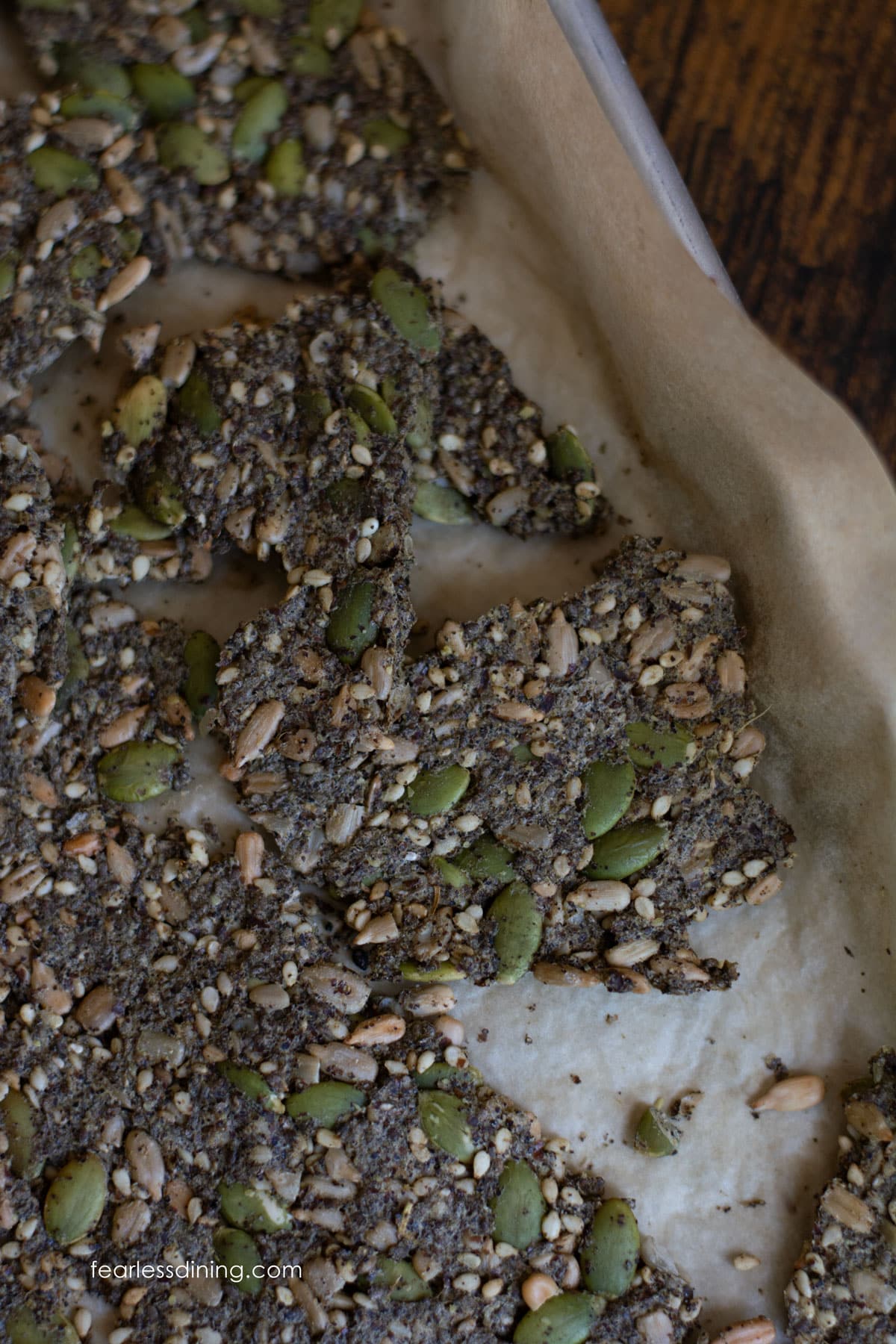 Broken seed crackers on a cookie sheet.
