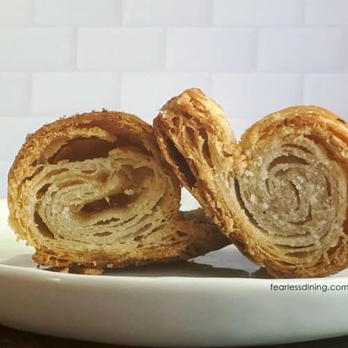 A gluten-free dairy-free rough puff pastry cut in half so you can see the flaky layers.