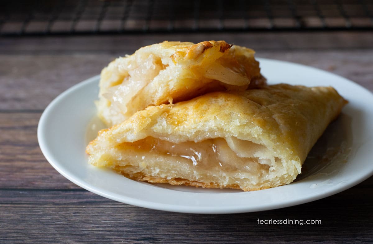 A close up of an apple turnover cut in half so you can see the apple filling.
