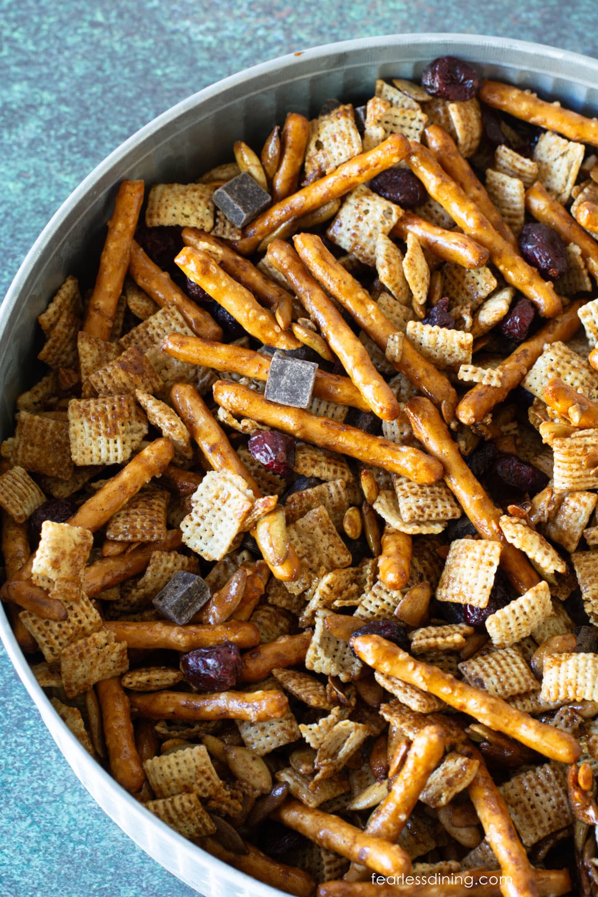The top view of the party mix in a silver metal serving dish.