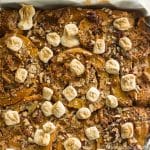 An 8x8 pan filled with baked gluten-free candied sweet potato cinnamon rolls.