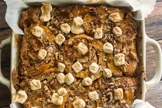 An 8x8 pan filled with baked gluten-free candied sweet potato cinnamon rolls.