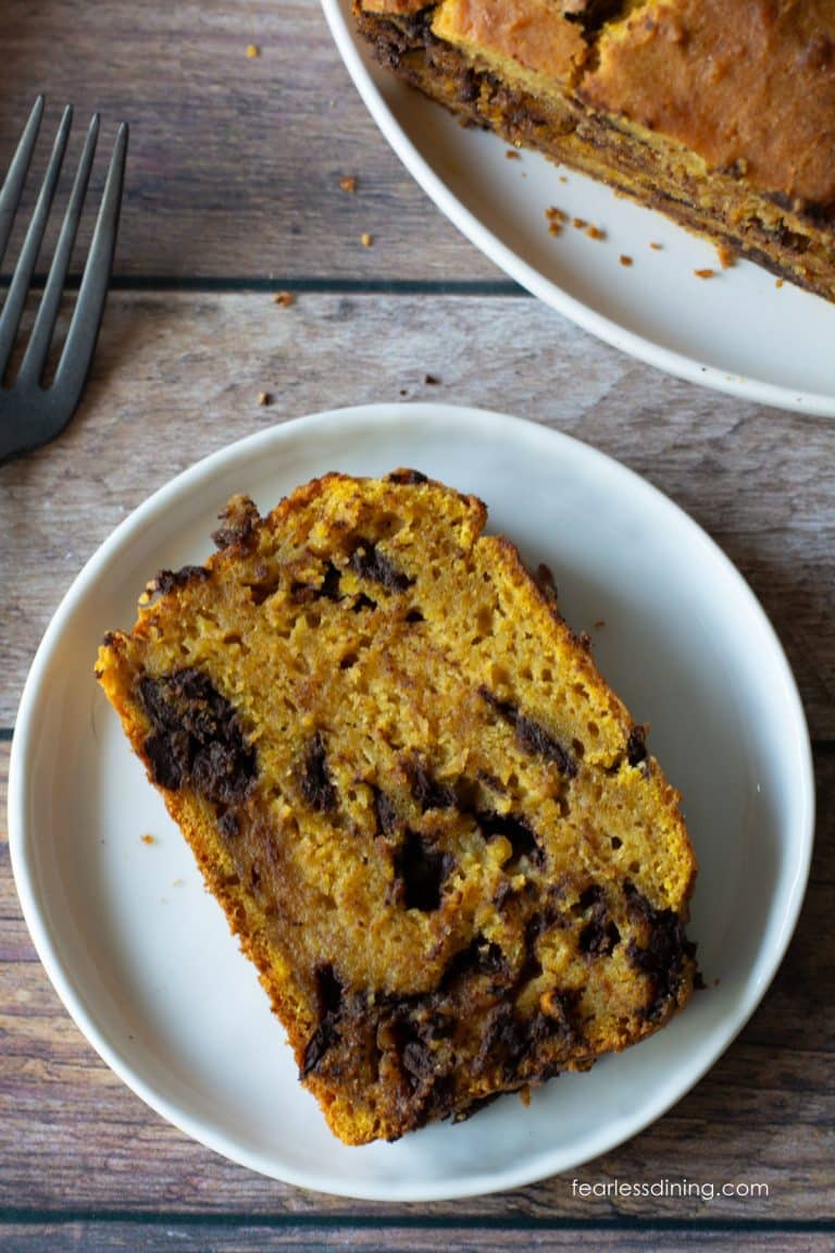 A slice of gluten-free banana pumpkin bread on a small white plate.