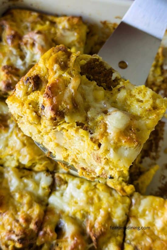 A closeup of a slice of pumpkin bread pudding being held up with a spatula.