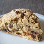 A gluten free fruit cake scone on a small white plate.