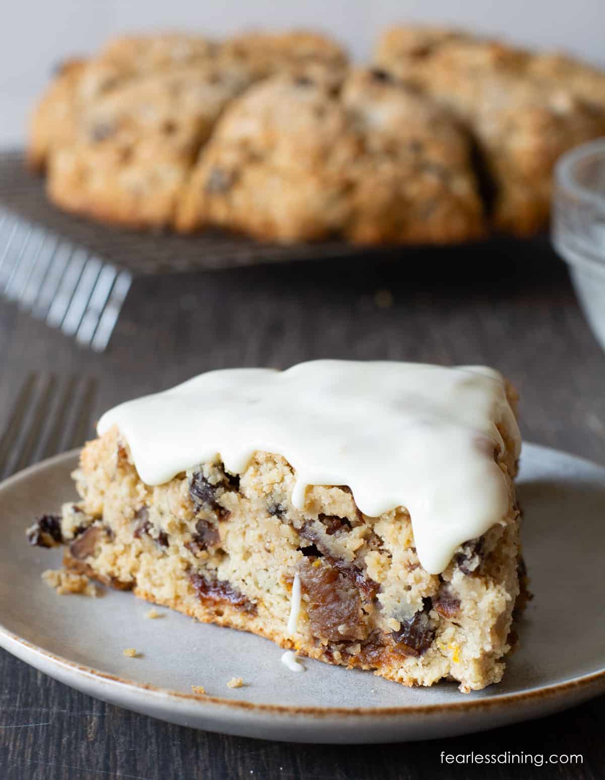 An iced fruitcake scone on a small plate.