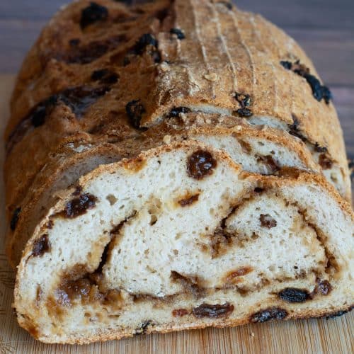 The front view of a sliced loaf of gluten-free artisan cinnamon raisin bread.