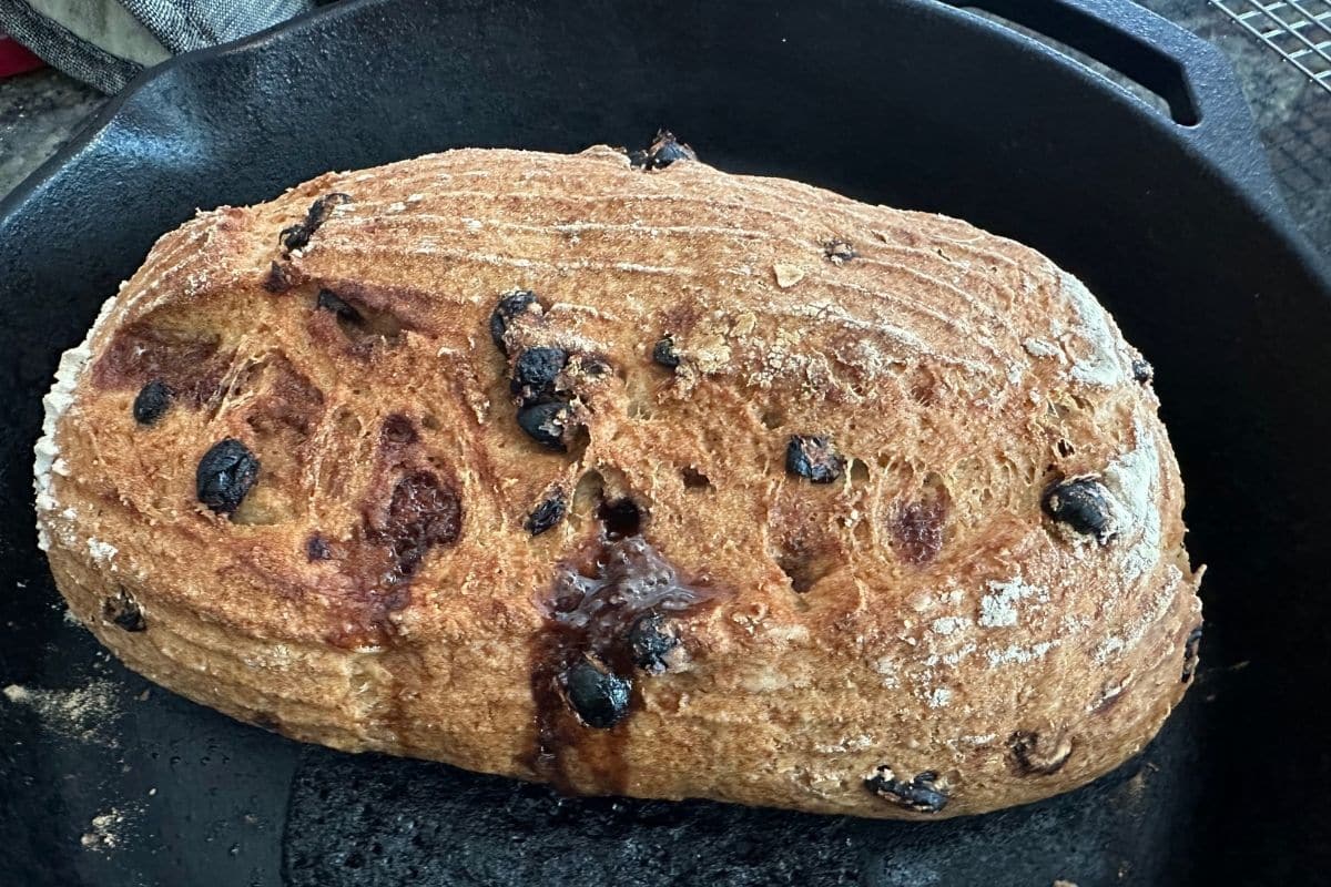 The baked loaf in the cast iron pan.