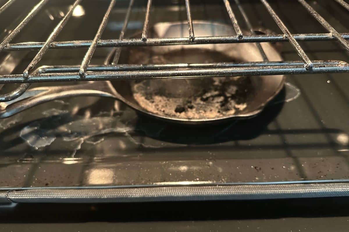 A cast iron skillet on the bottom of the oven.