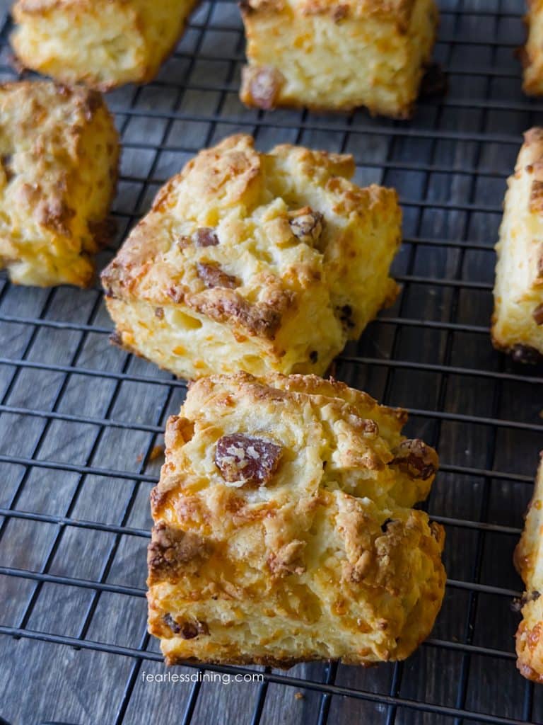 A close up of the gluten free biscuits with bacon and cheese on a cooling rack.