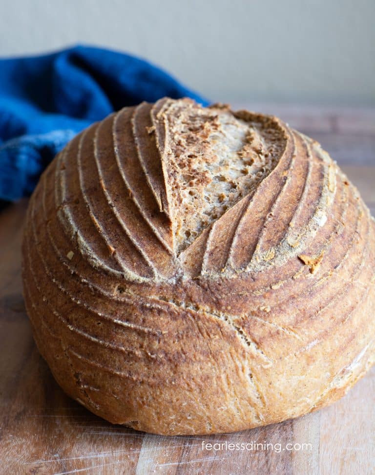 The front view of my artisan gluten free whole grain sourdough bread on a wooden cutting board.