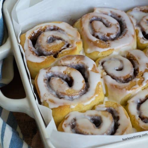 A baking dish filled with iced gluten free sourdough cinnamon rolls.