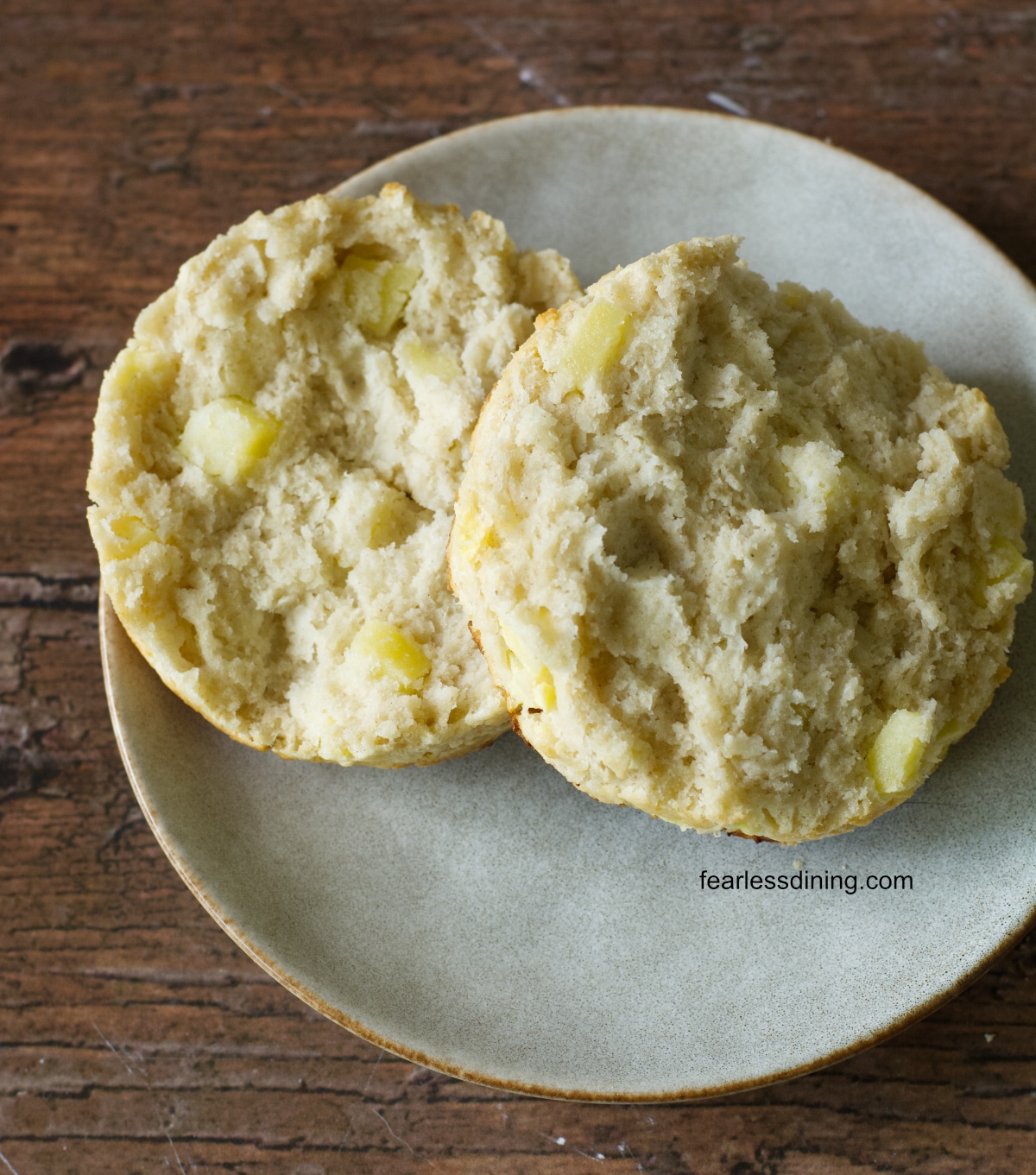 A photo of a biscuit cut in half so you can see the flaky layers and apple bits.