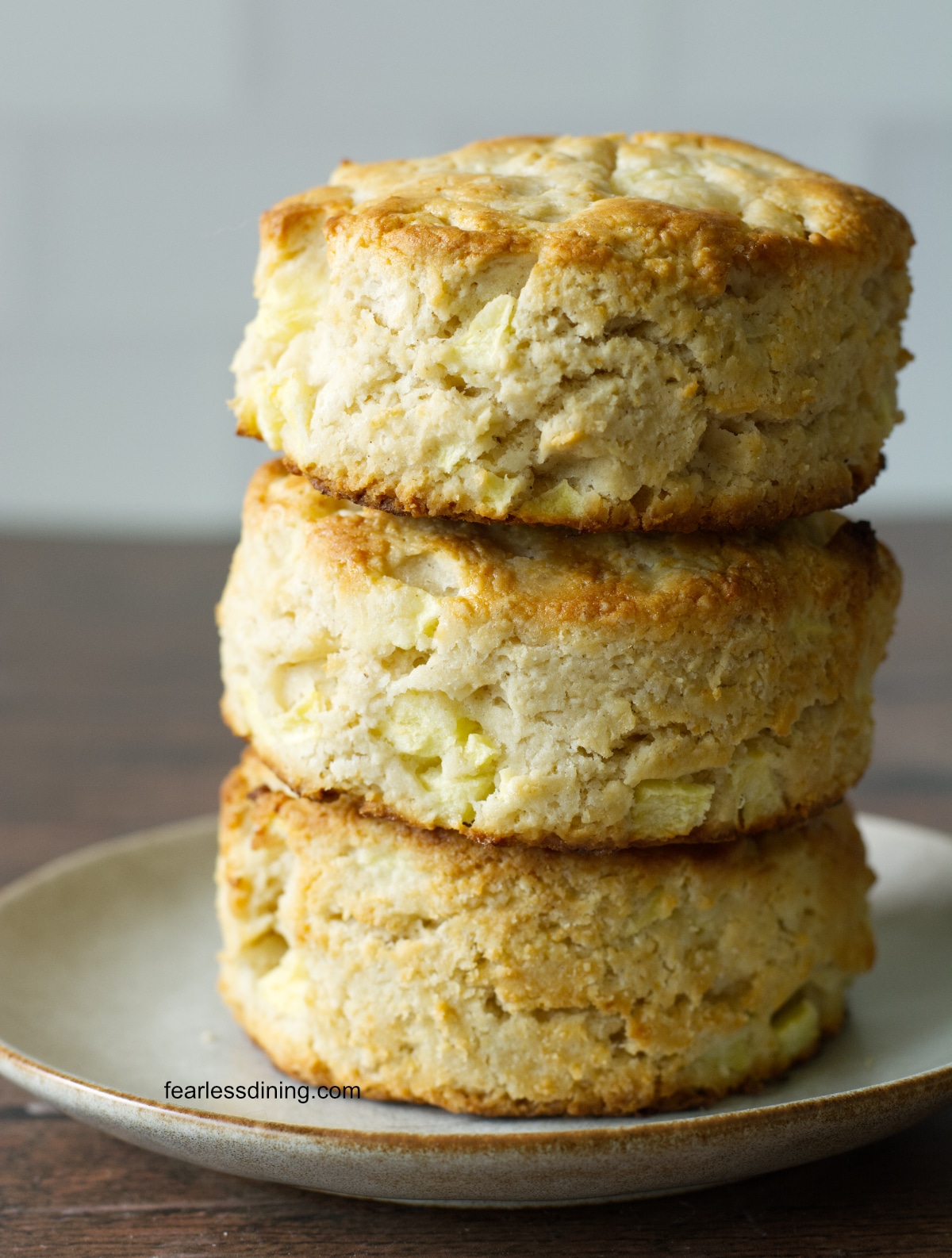 A stack of three gluten free apple biscuits on a small plate.