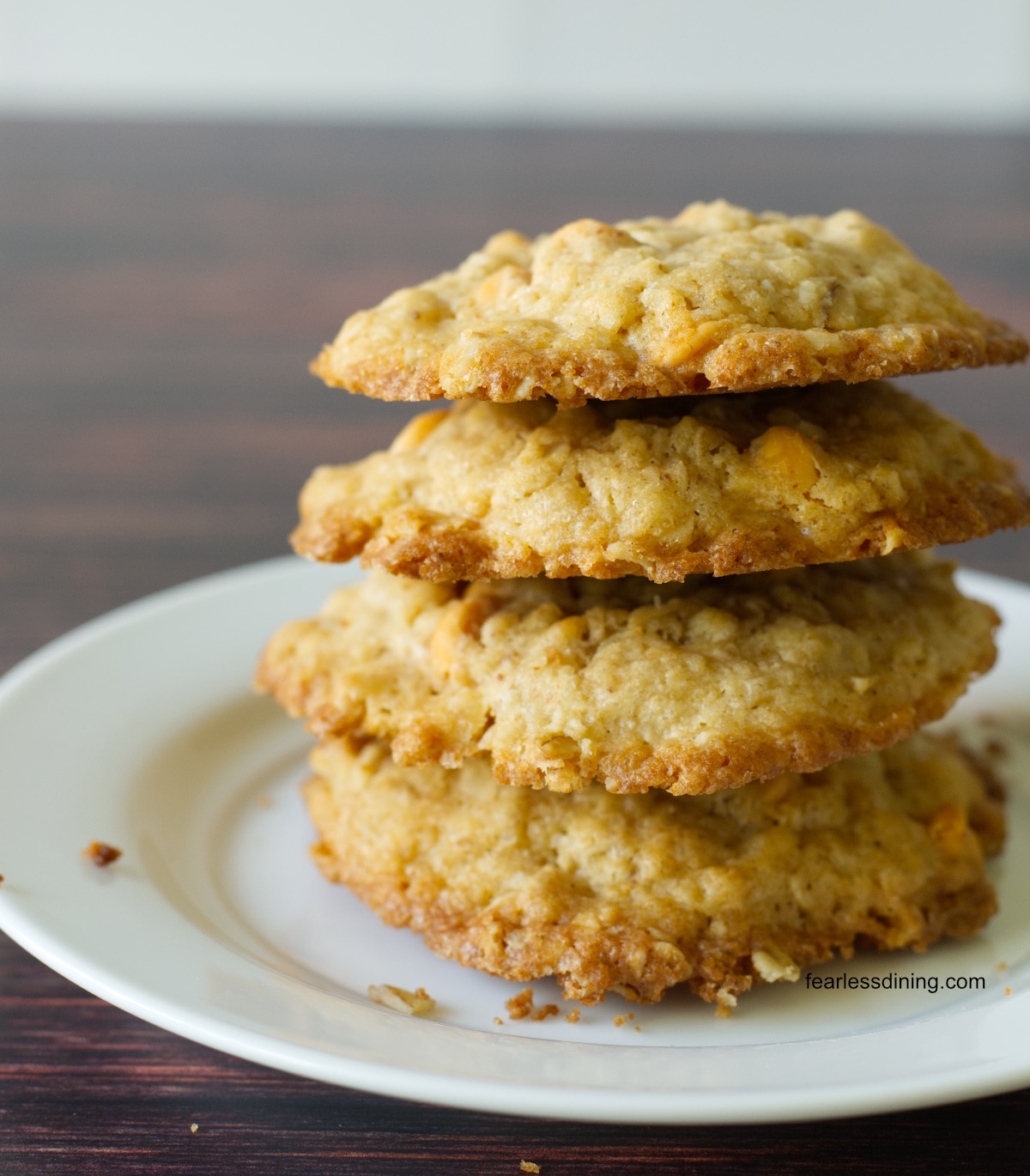 A stack of four gluten free cookies on a white plate.