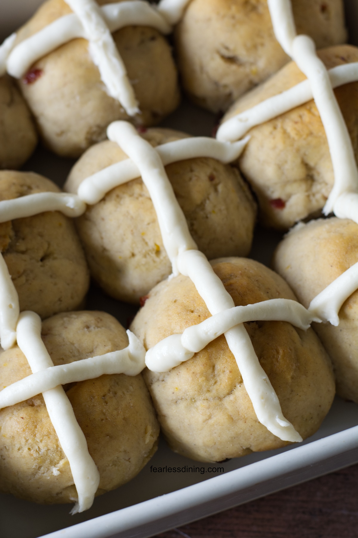Baked gluten free hot cross buns in a baking dish.