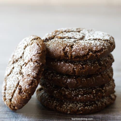 A stack of gluten free spiced molasses cookies on a tray.