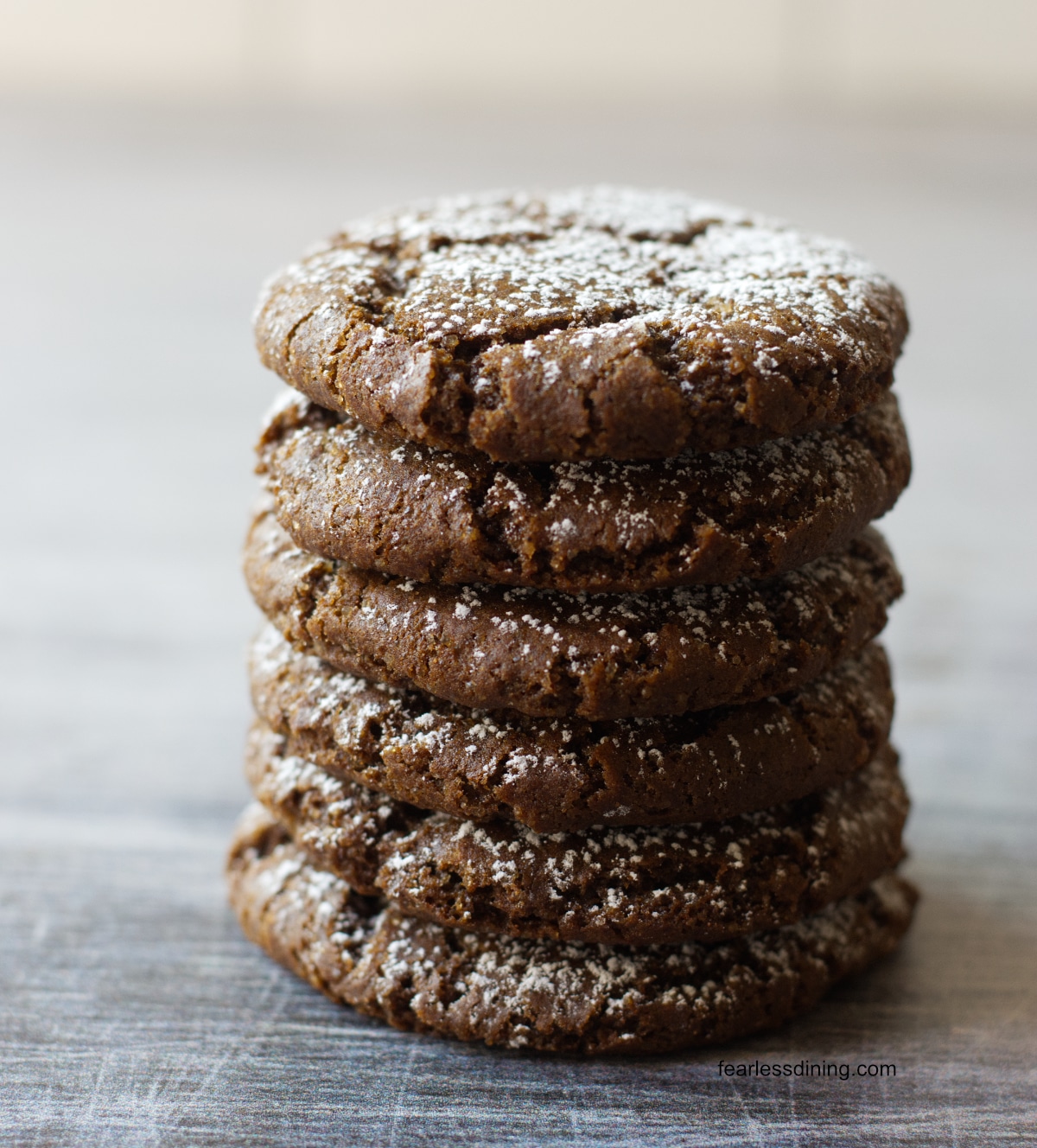 A stack of six gluten free spiced molasses cookies on a counter.