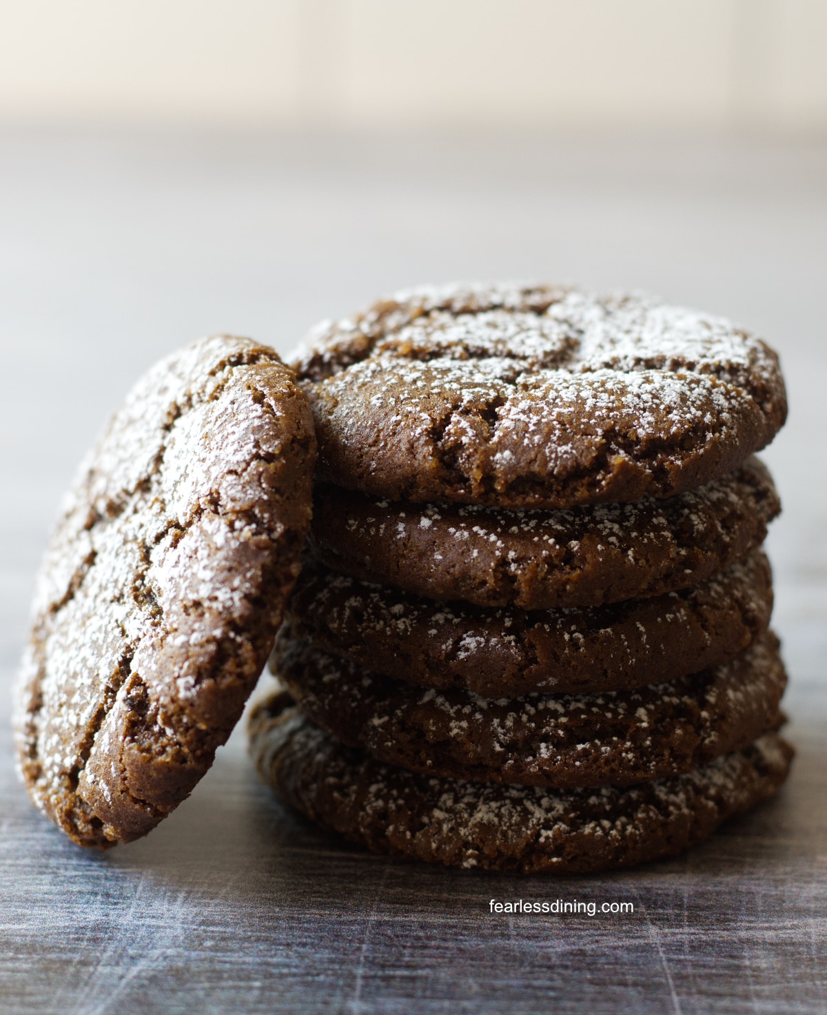 A stack of gluten free spiced molasses cookies on a tray.