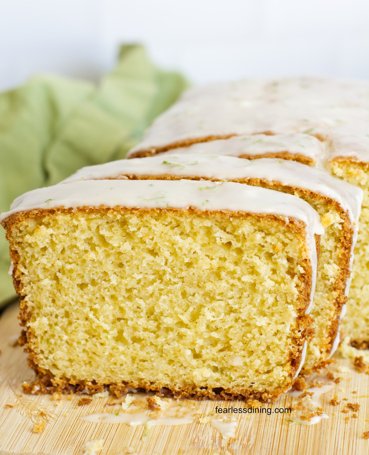 A close up of the gluten free olive oil cake with lime on a cutting board.