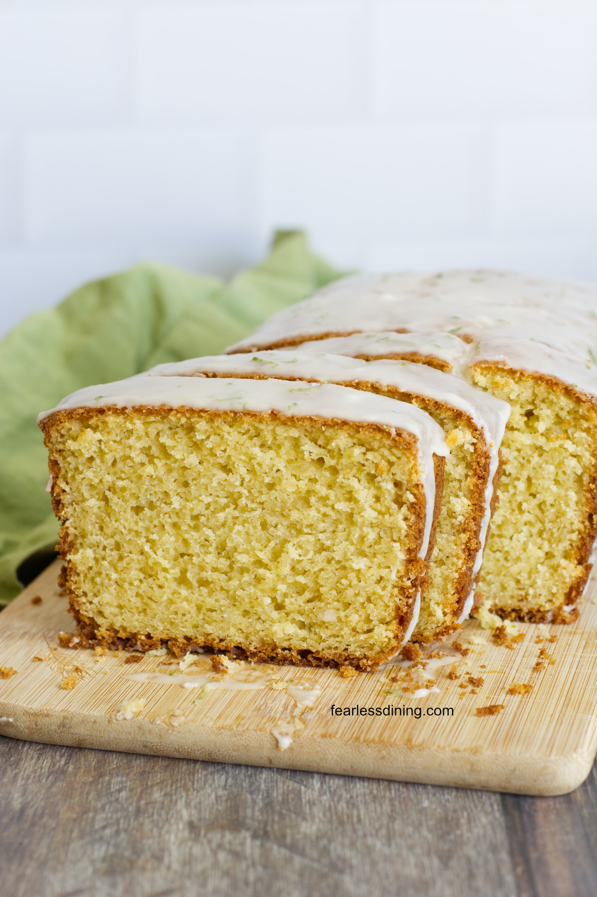The gluten free olive oil cake sliced on a cutting board.