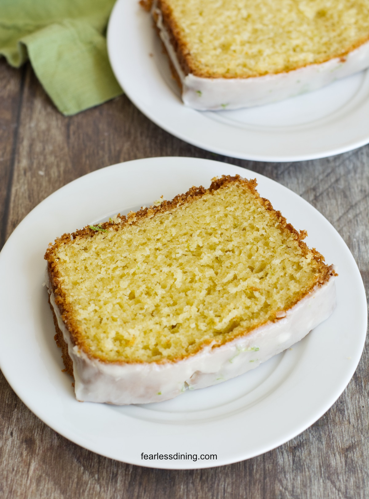 Two plates with slices of lime olive oil cake.