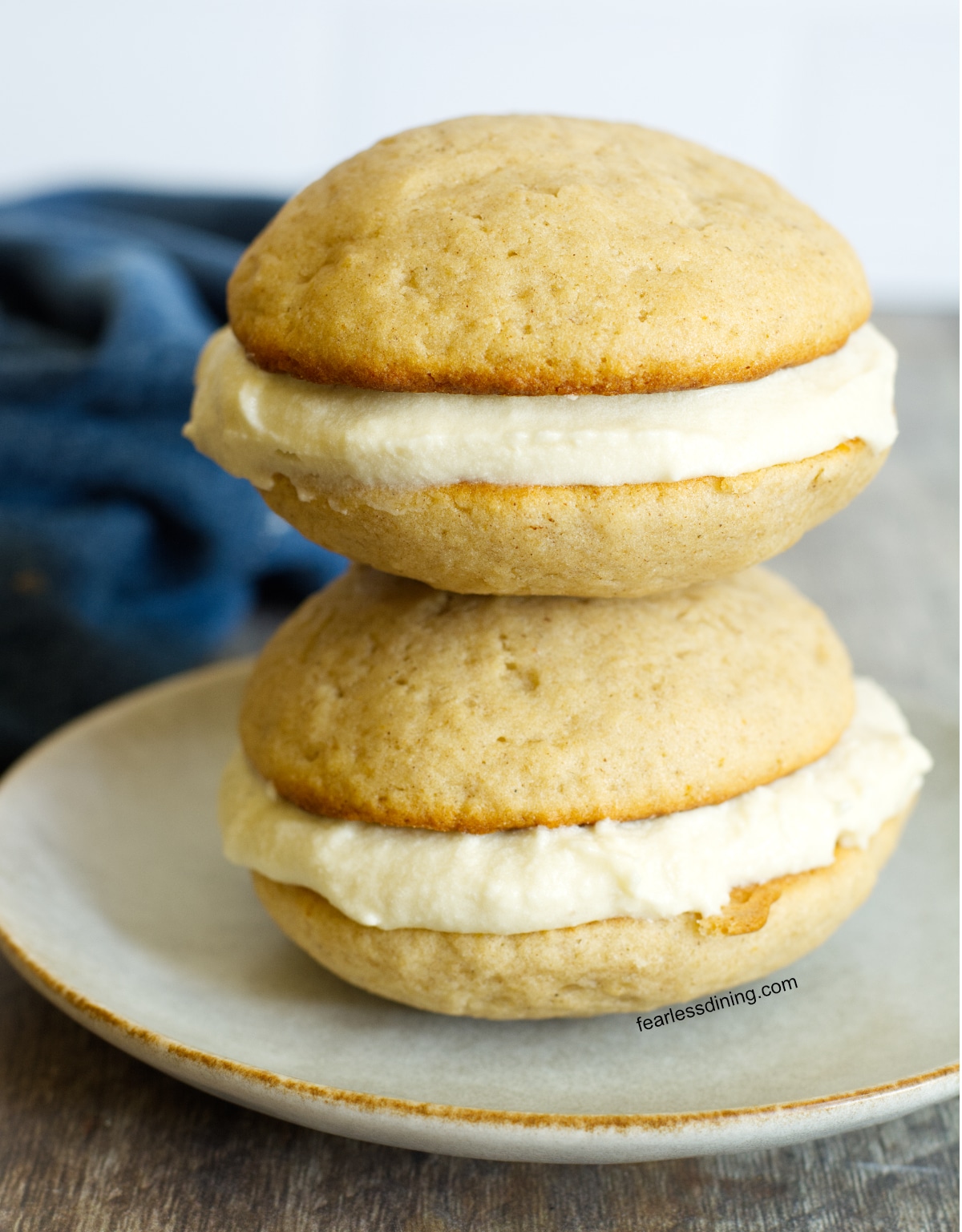 Two glute free apple cider whoopie pies on a plate.