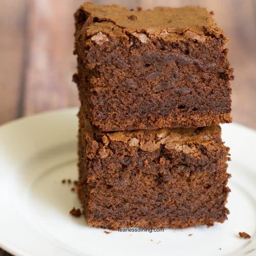 A stack of two gluten free sourdough discard brownies on a plate.