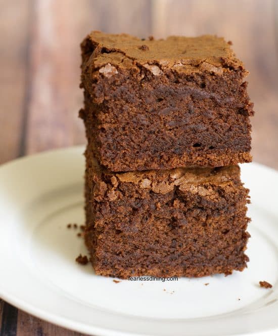 A stack of two gluten free sourdough discard brownies on a plate.