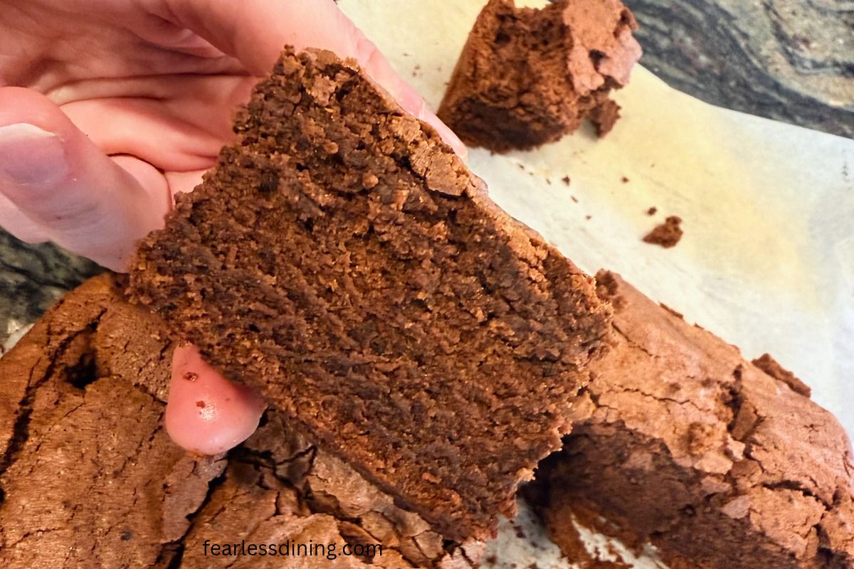 Holding up a cut brownie.