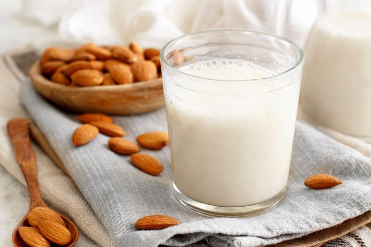 a glass of almond milk on a grey cloth napkin