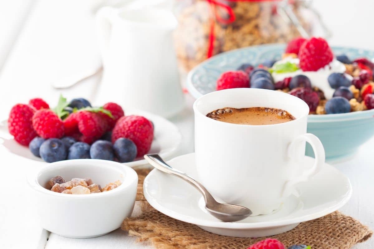 breakfast on a table with cereal, fresh berries, and coffee.