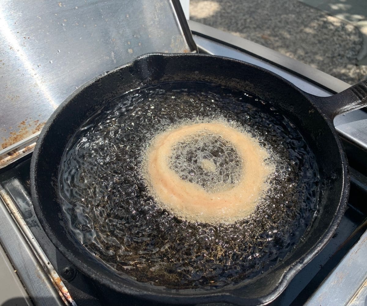 a large onion ring frying in oil.