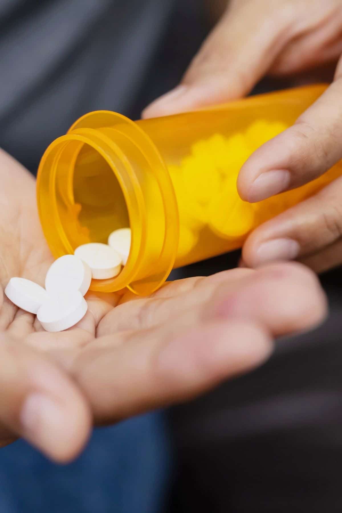 pouring pills out of a medication bottle.