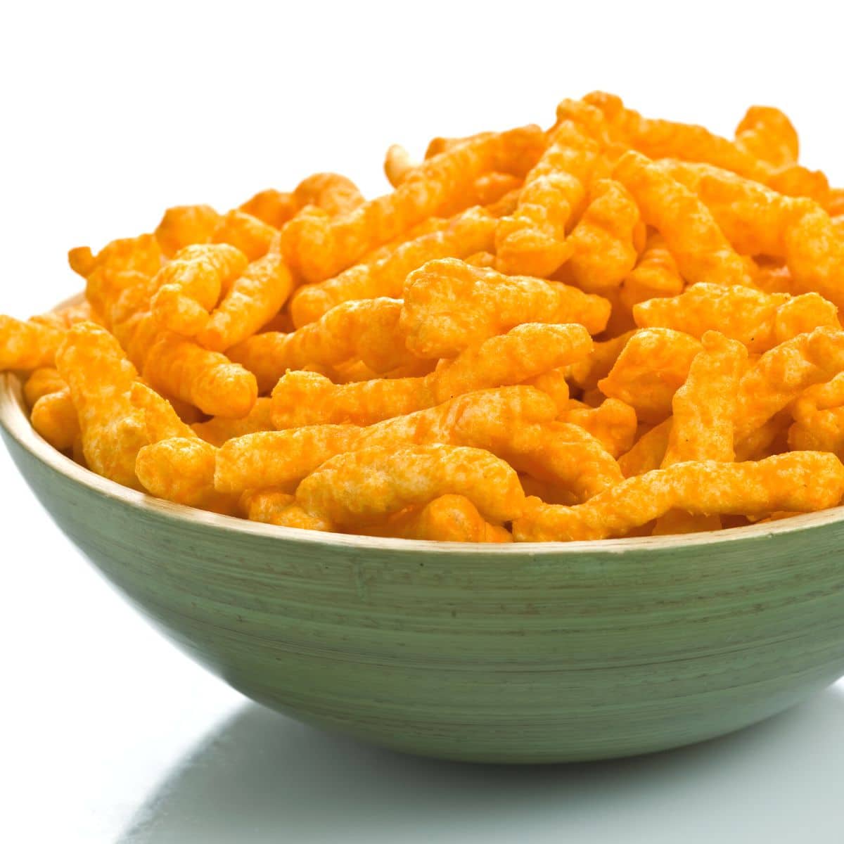 A green bowl filled with Cheetos.