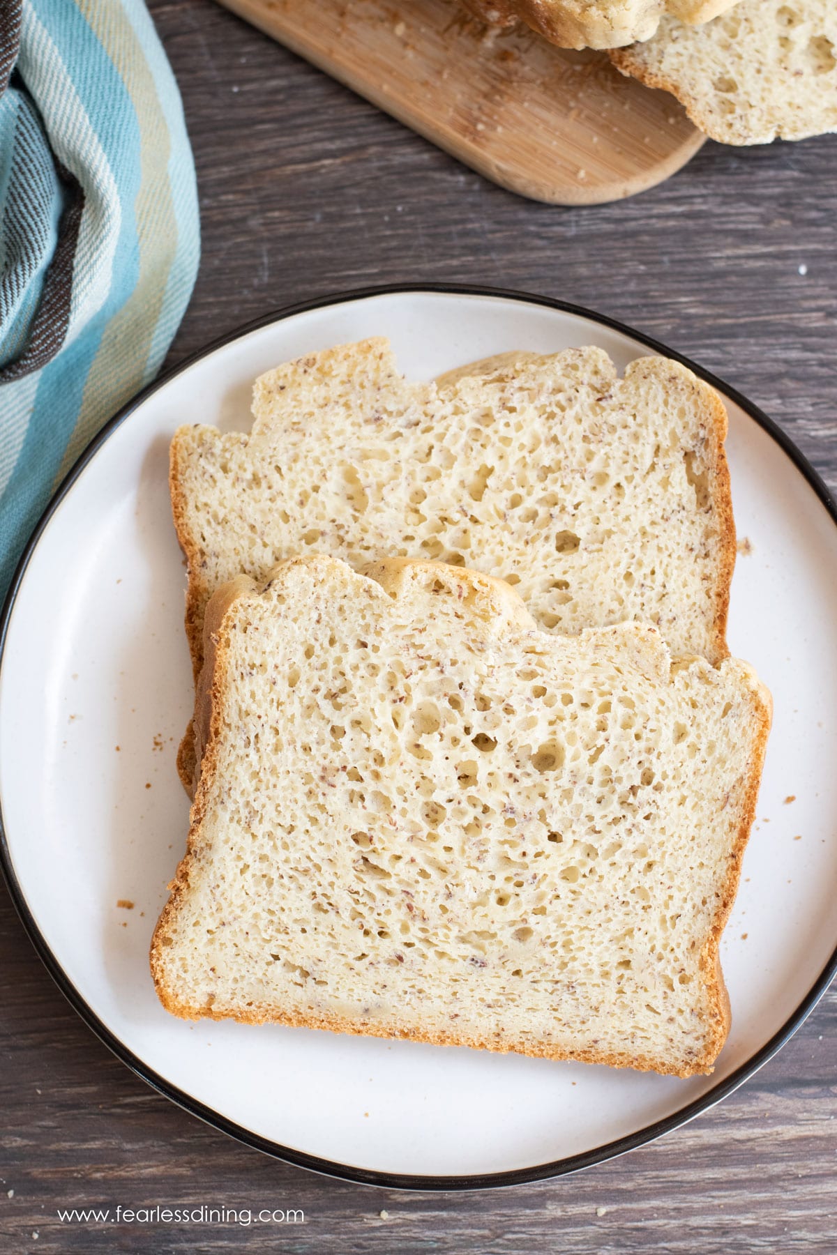 Two slices of gluten free bread on a white plate.